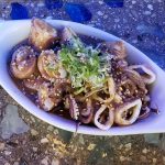 Cooked baby squid, stuffed with crab, submerged in a ginger sauce