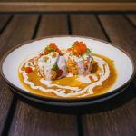 Tuna, albacore, and avocado, wrapped around a spicy crab ball, with a mixture of sauces and masago