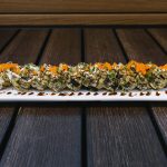 Inside: crab, shrimp, cream cheese and avocado Outside: deep fried in tempura batter and drizzled with cream & sweet sauce, topped with masago and green onion