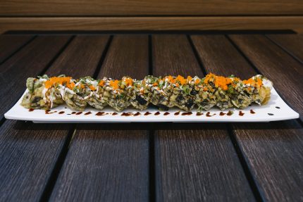 Inside: crab, shrimp, cream cheese and avocado Outside: deep fried in tempura batter and drizzled with cream & sweet sauce, topped with masago and green onion