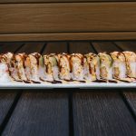 Inside: shrimp tempura and crab Outside: spicy crab, avocado, drizzled with spicy mayo and sweet sauce all wrapped in a pink soy paper!