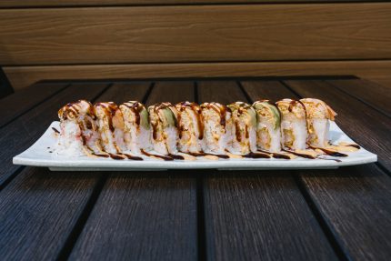 Inside: shrimp tempura and crab Outside: spicy crab, avocado, drizzled with spicy mayo and sweet sauce all wrapped in a pink soy paper!
